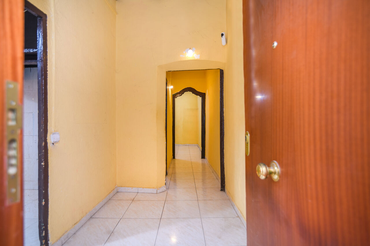 Entry hallway before renovation — yellow walls, original arched doorways