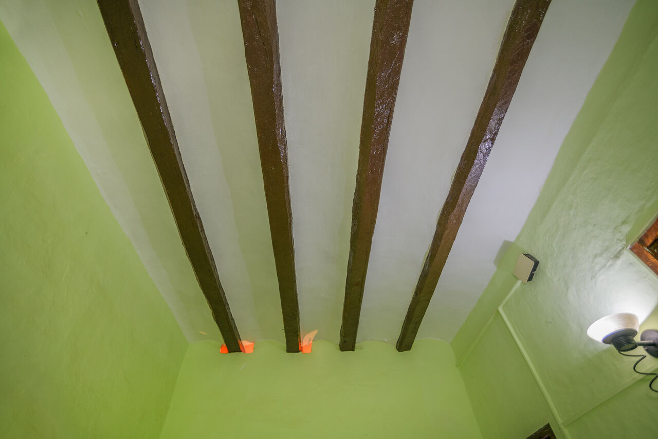Living room before renovation — green walls, exposed wooden beams