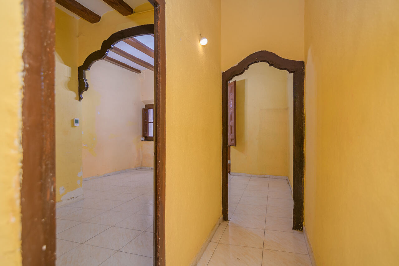 Bedroom corridor before renovation — yellow walls and arched openings